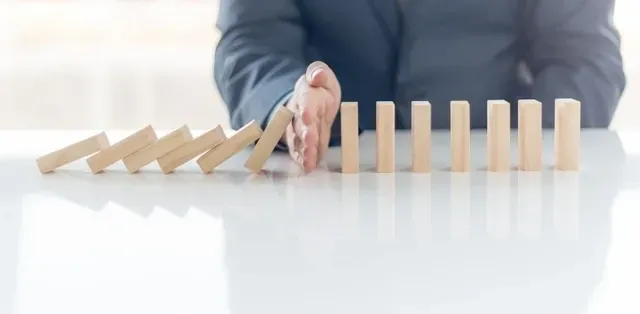 A person is playing with wooden blocks on the table